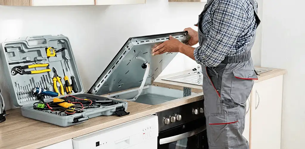 Handyman repairing a cooktop and checking wiring connections in Anaheim, CA