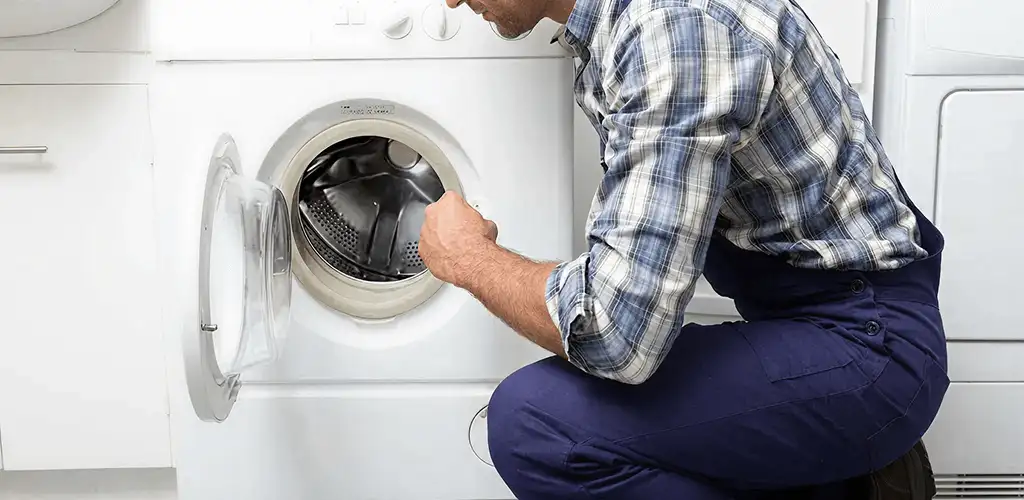 Handyman inspecting a dryer drum and internal parts for repair in Anaheim, CA