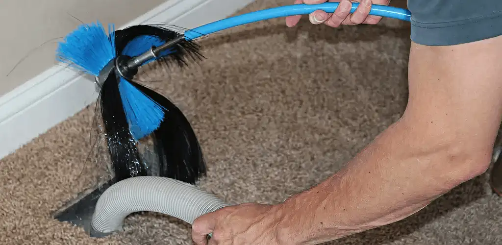 Dryer vent cleaning technician brushing lint from a vent line in Anaheim, CA
