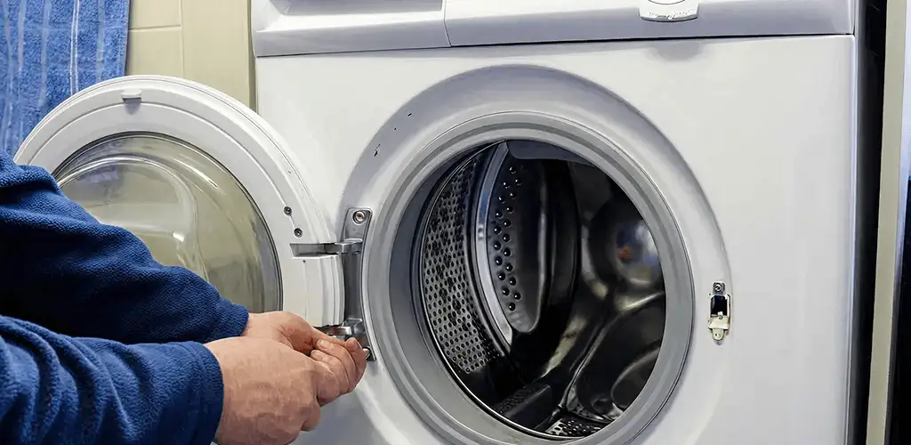 Washing machine repair handyman checking a front-load washer door and latch in Anaheim, CA