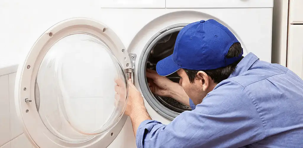 Washing machine repair handyman inspecting a front-load washer drum in Anaheim, CA