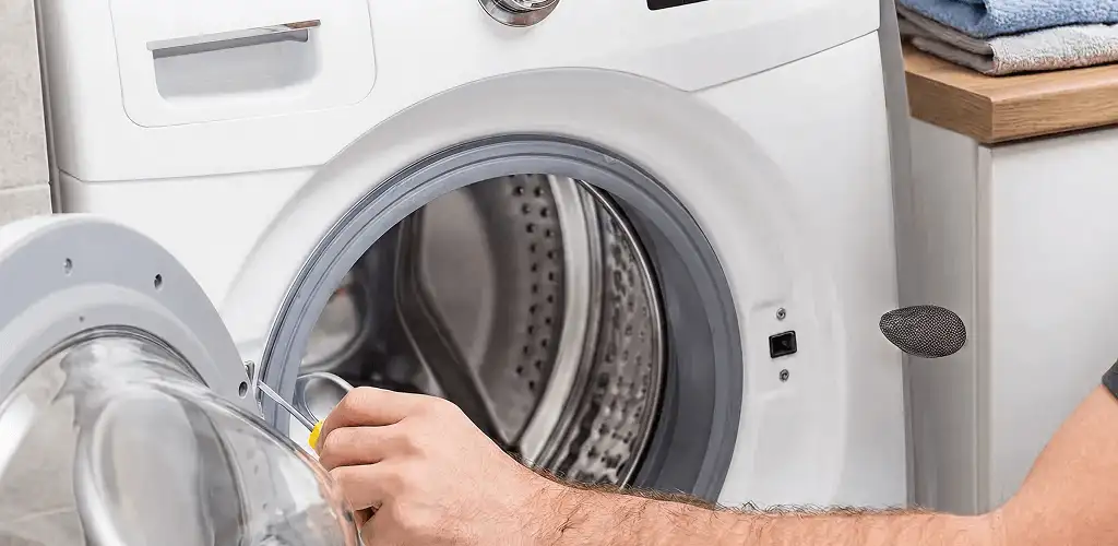 Handyman repairing a front-load washing machine and inspecting the drum in Anaheim, CA
